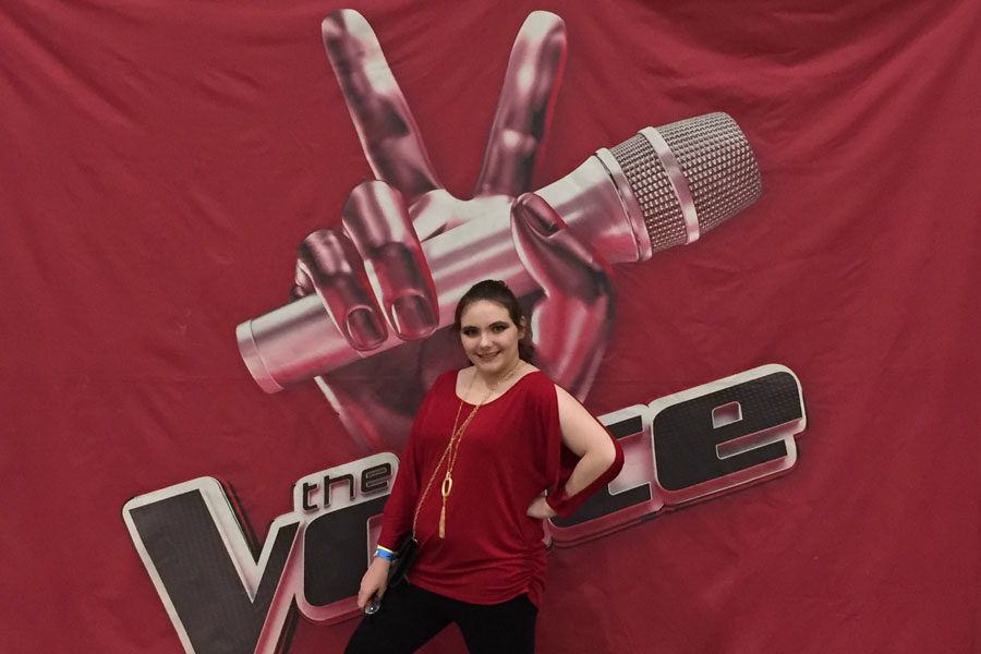 Elizabeth Hall poses in front of The Voice logo before her audition.