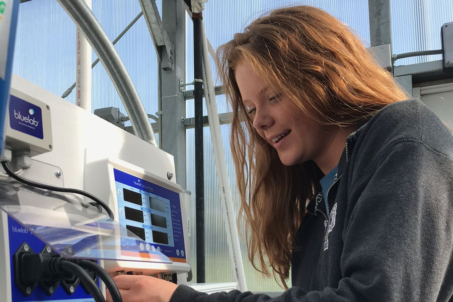 Junior Allisan Whitaker works with the fertillizer tanks of the hydroponics system in the Ag Department.