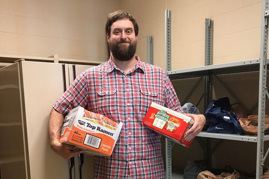 Mr. Foudray poses with some food bank items.