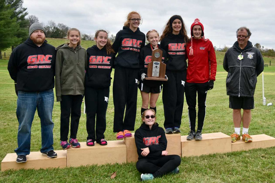 Girls Cross Country team poses with Region trophy.