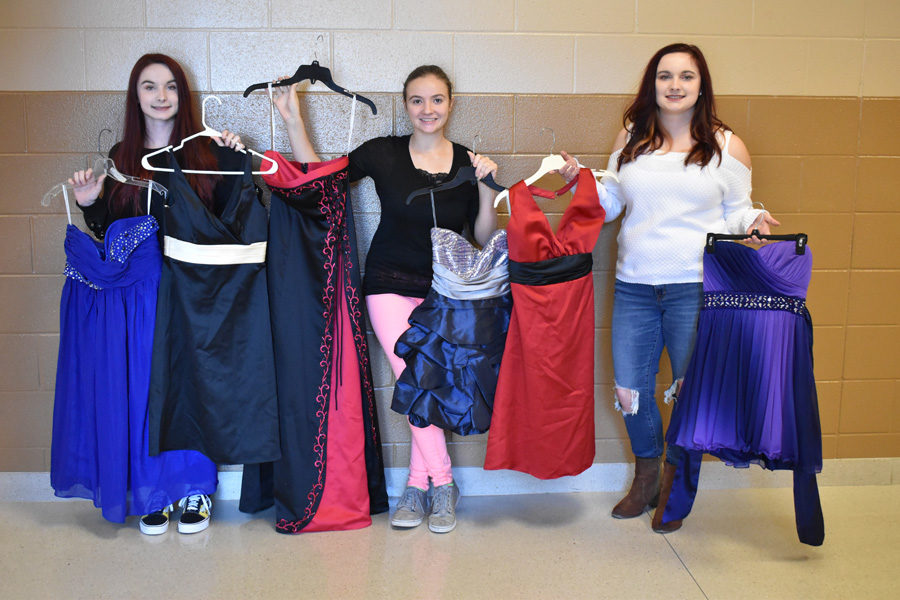 From left, Shana Rose, Haily Bush, and Katie Rose pose with the dresses.