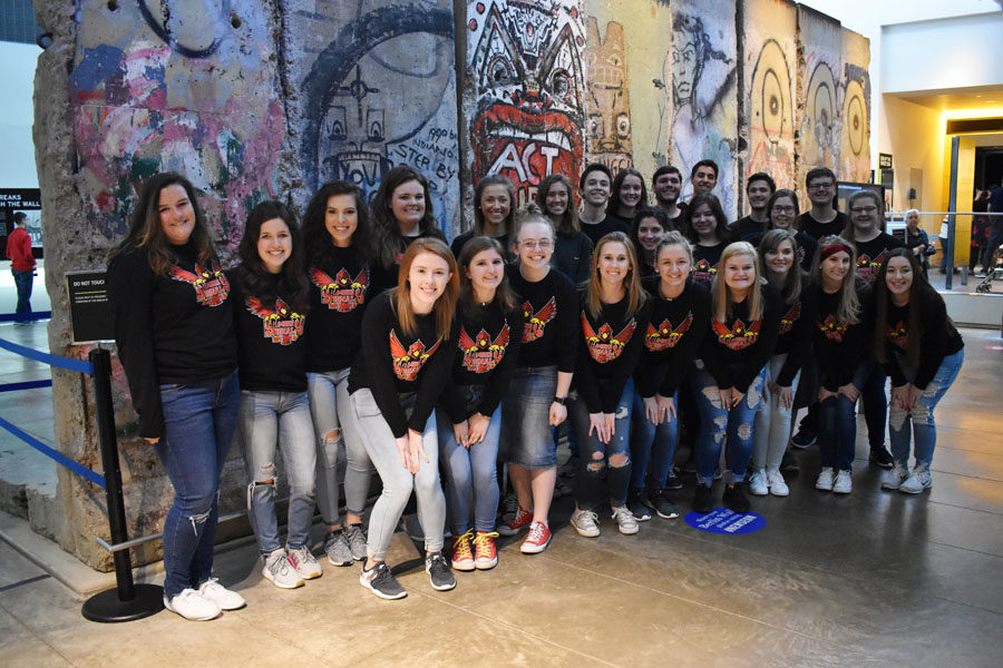 The Smoke Signals Staff Poses in Front of a Piece of the Berlin Wall.